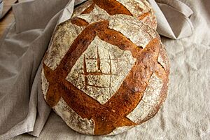 Tourte de Meule (Sauerteig-Experiment). Das Tourte de Meule liegt kräftig ausgebacken auf einem Leinentuch.