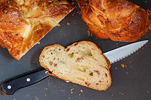 Die angeschnittene Brioche zeigt Käse- und Speckwürfel in der wattigen, elastischen Krume.