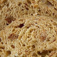 In der lockeren Krume werden kleine und große, dunklere und hellere Krümel und Brocken des eingearbeiteten Brotes sichtbar.