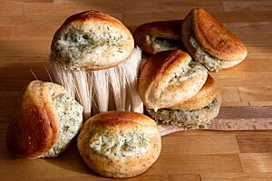 In der Kruste der ausgebackenen Teigmuscheln ist der Vollkornanteil zu sehen. Sie sind mit einer Mischung aus Ziegenkäse, Dill und Parmesan gefüllt.