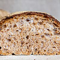 Umgeben von der dunkel ausgebackenen Kruste zeigt sich im Anschnitt des Basler Brotes die saftige, elastische Krume.