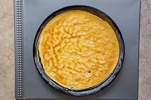 Herrlich fluffig und goldgelb ausgebacken liegt die Neudorfer Eierschecke in einer runden Kuchenform.