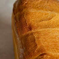 Die Kruste des Toastbrotes ist goldbraun ausgebacken und knusprig.