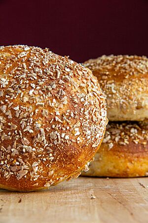 Fünfkornlinge. Die goldbraun ausgebacken, in Schrot gewälzten Brötchen haben eine glatte Kruste.