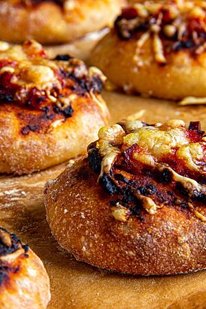 Pizzabrötchen. Die kräftig ausgebackenen Pizzabrötchen sind mit Tomatenmark, Kochschinken und zerlaufenem Käse belegt.