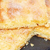 Die weiche, saftige Krume des Zuckerkuchens ist von einer knusprigen, karamellisierten Zuckerschicht bedeckt.