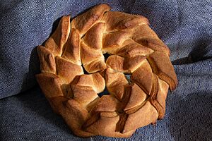 Das goldbraun ausgebackene Dachziegelbrot mit seiner matten Oberfläche besteht aus vielen kleinen Rauten, die kreisförmig in einer Lage dachziegelartig übereinander gelegt wurden.