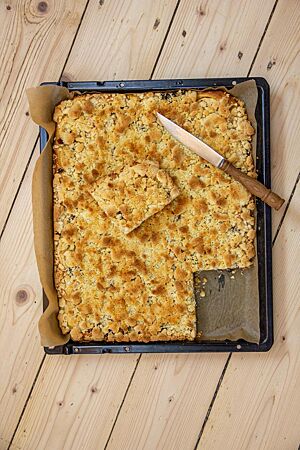 Neidarfer Äppelkung (Neudorfer Apfelkuchen). Der Neidarfer Äppelkung liegt goldgelb ausgebacken auf einem Blech.