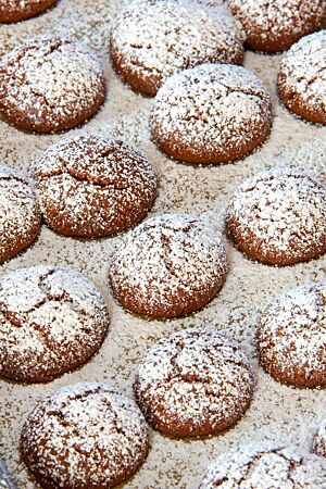 Die Oberfläche der gebackenen Schokoladenplätzchen ist in der Mitte leicht aufgebrochen und üppig mit Puderzucker bedeckt.