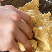 Eine Mischung aus Butter und Gewürzen wird in einer Schüssel von Hand geknetet.