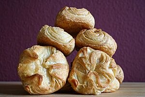 Die goldgelb ausgebackenen Kieler Franzbrötchen liegen zu einer Pyramide gestapelt auf einem Tisch.