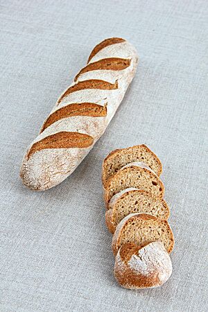 Das stangenförmige Gerstenbrot hat eine kräftig ausgebackene Kruste und eine lockere, kleinporige Krume.