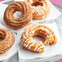 Die aus Brandteig hergestellten, ringförmigen Spritzenkuchen wurden in Zimtzucker gewälzt oder mit Zuckerguss verziert.
