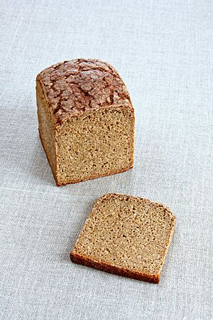 Das im Kasten gebackene Einkorn-Hafer-Brot zeigt angeschnitten seine kleinporige Krume und die auf der Oberfläche von Rissen durchzogene Kruste.