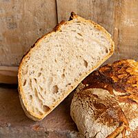 Die Krume des Weizensauerteigruchbrotes ist locker und elastisch, die Kruste rustikal und goldbraun ausgebacken.