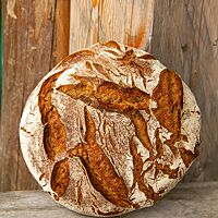 Das Roggenvollkornbrot hat eine rustikal aufgerissene, bemehlte Kruste.
