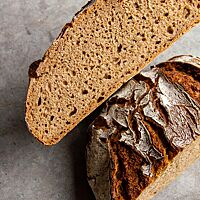 Im Anschnitt zeigt das Roggenvollkornbrot seine kleinporige, hellbraun gefärbte Krume.
