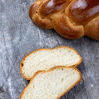 Die helle, elastische Krume des Hefezopfes ist umgeben von einer goldbraun ausgebackenen, dünnen Kruste.