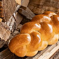 Der goldbraun ausgebackene Sauerteigzopf hat eine glatte, glänzende Oberfläche.