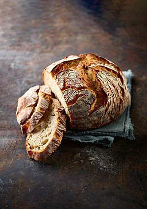 Das Mischbrot mit Roggen zeigt seine kräftig ausgebackene, wild aufgerissene Kruste und die elastische, mittelporige Krume.