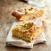 Die quadratischen, flachen Handbrotstücke sind knusprig mit Käse überbacken.