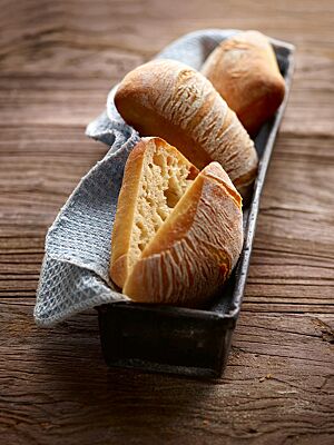 Die rechteckigen Weizenbrötchen mit fein gemaserter und leicht bemehlter Kruste haben eine lockere, mittelporige Krume.