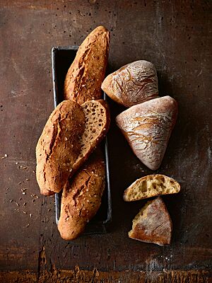 Sowohl die länglich geformten Dinkelseelen (links) als auch die dreieckigen Dreikornbrötchen (rechts) haben eine lockere, mittelporige Krume.