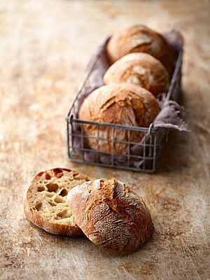 Die runden Mischbrötchen haben eine rustikal aufgerissene, goldbraun ausgebackene Kruste und eine lockere Krume mit wilder Porung.