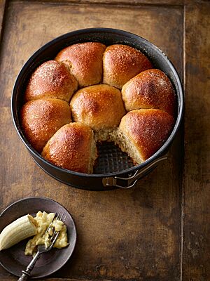 In einer Springform liegen dicht aneinandergebacken mehrere goldbraune Brötchen mit weicher, saftiger Krume.