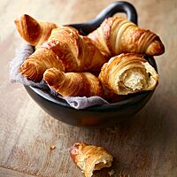 Die Butterhörnchen sind glänzende, blättrige Croissants, die goldbraun ausgebacken wurden.