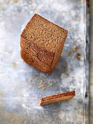 Das Roggenschrotbrot wurde in einer Kastenform gebacken und hat eine dünne, glatte Kruste und eine dichte, kleinporige Krume.