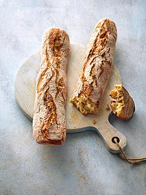 Die Dinkelstangen in Form von Baguettes haben eine lockere, elastische Krume mit wilder Porung und eine knusprige, rustikal aufgerissene Kruste.