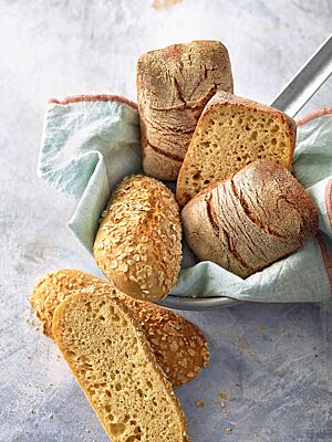 Sowohl die länglichen, mit Haferflocken bestreuten Dinkel-Joghurt-Brötchen (unten) als auch die eckigen, leicht bemehlten Dinkel-Bier-Brötchen (oben) haben eine kleinporige, lockere Krume.