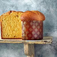 Die in einer Panettone-Papierform gebackene Brioche hat eine goldgelbe, fluffige Krume und eine glatte, goldbraun ausgebackene Kruste.