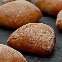 Die eckigen Weizenbrötchen haben eine feine, hellbraun ausgebackene und leicht bemehlte Kruste.
