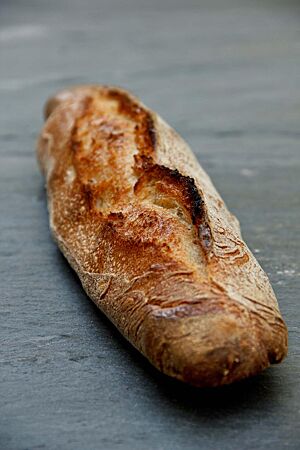 Die rustikal aufgerissene Kruste des Baguettes ist knusprig ausgebacken.