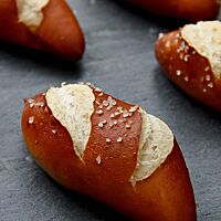 Die länglichen Laugenbrötchen haben eine feine, mit Salz bestreute Kruste.
