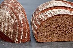 Die kleinporige, dunkelbraun gefärbte Krume des Dinkelvollkornbrotes ist von einer kräftig ausgebackenen, bemehlten Kruste umgeben.