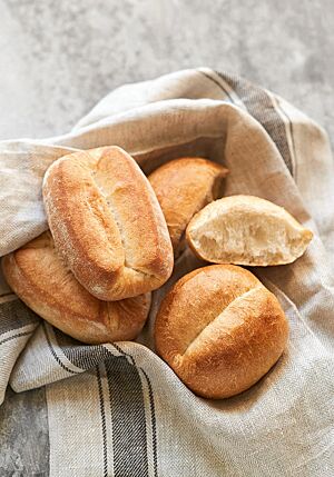 Sowohl die länglichen, leicht eckigen Knüppel mit leicht bemehlter Oberfläche (links) als auch die runden Dampfbrötchen mit leicht glänzender Kruste (rechts) haben einen weit geöffneten Schluss.
