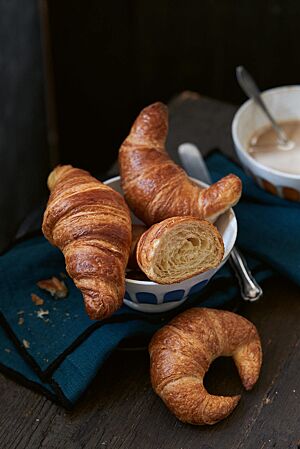 Pariser Gipfel (oben rechts), Bamberger Hörnla (unten) und Croissants (oben links) liegen in einem weißen Schälchen. Die stark gebogenen Bamberger Hörnla haben eine goldbraun ausgebackene, glänzende Kruste und eine feinblättrige, buttrige Krume.