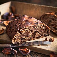Das halbierte Kletzenbrot hat eine dunkle, glatte Kruste mit Ausstülpungen, die durch die eingearbeiteten Trockenfrüchte entstanden sind. Die sehr saftige, dunkle Krume ist aufgrund der großen Menge an Trockenfrüchten sehr kompakt.