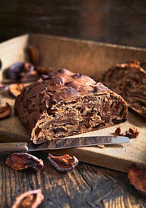 Das halbierte Kletzenbrot hat eine dunkle, glatte Kruste mit Ausstülpungen, die durch die eingearbeiteten Trockenfrüchte entstanden sind. Die sehr saftige, dunkle Krume ist aufgrund der großen Menge an Trockenfrüchten sehr kompakt.