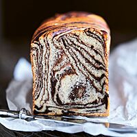 Die im Anschnitt sichtbare Krume des Wirbelbrotes erinnert an das Streifenmuster eines Zebras. Die dünneren dunkelbraunen Linien wechseln sich mit den breiteren, helleren Bereichen ab.