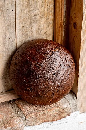 Das dunkelbraun ausgebackene Roggenbrot hat eine glatte, glänzende Kruste.