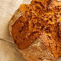 Die kräftig ausgebackene Kruste des Irish Soda Bread ist rustikal aufgerissen.